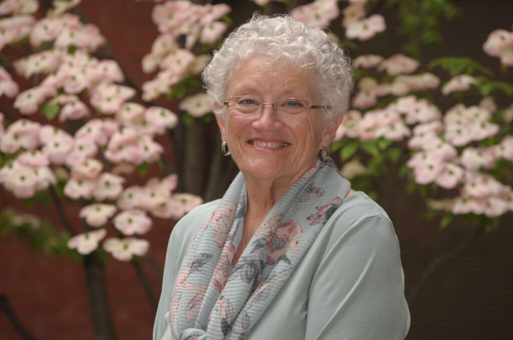 A three quarters informal portrait of Diane in front of a dogwood