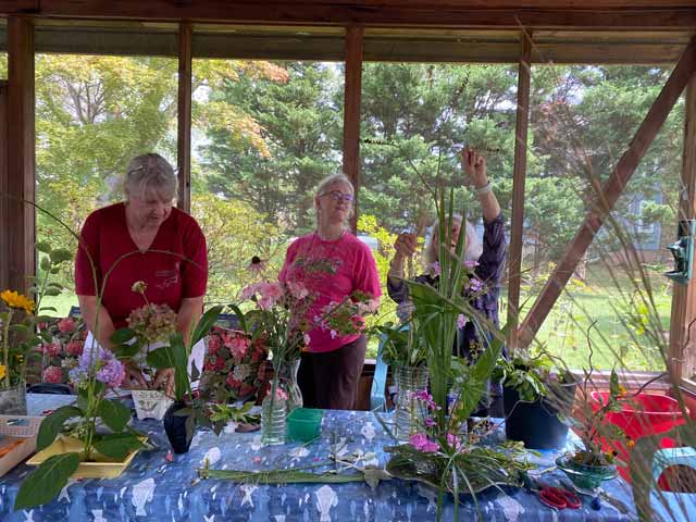Three ladies around a table during a flower arrangement workshop