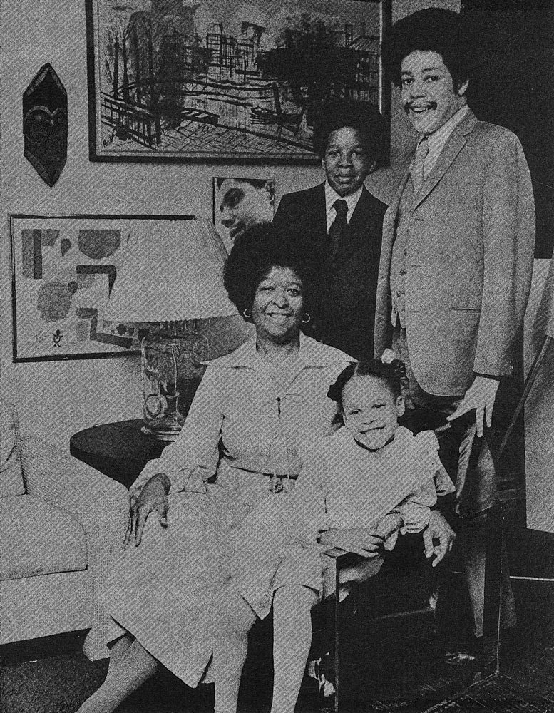 A newspaper picture from the 1970's show a family portrait of middle class african american family; a father, a mother, a son and daughter, they all smiling.
