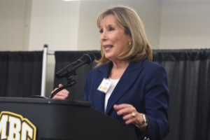 A woman at a podium discussing issues to an audience